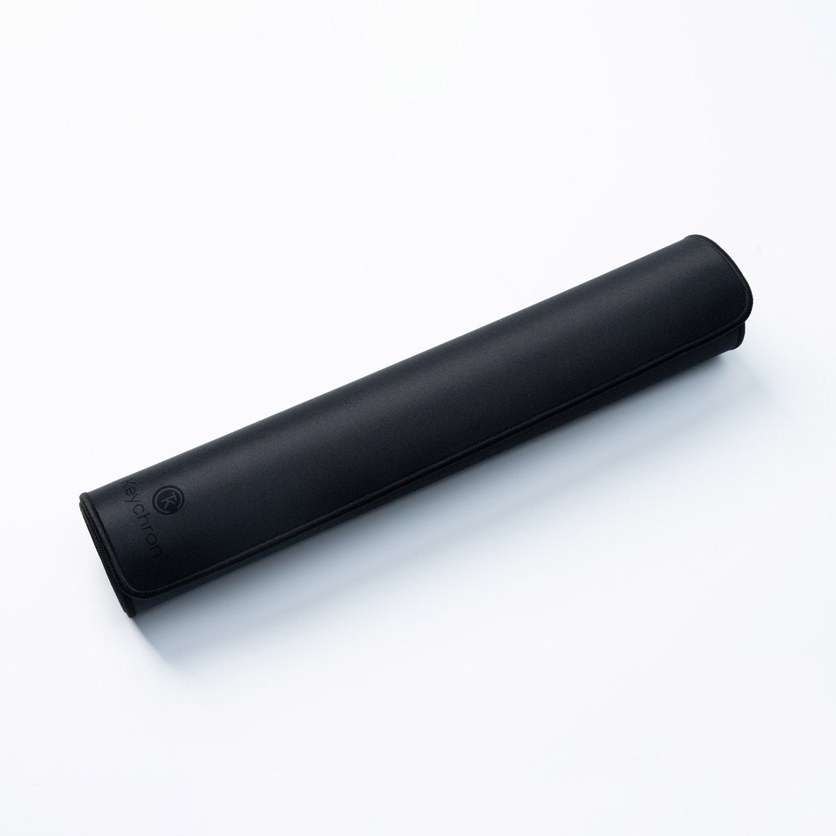 Keychron Desk Mat in Black, rolled up for travel